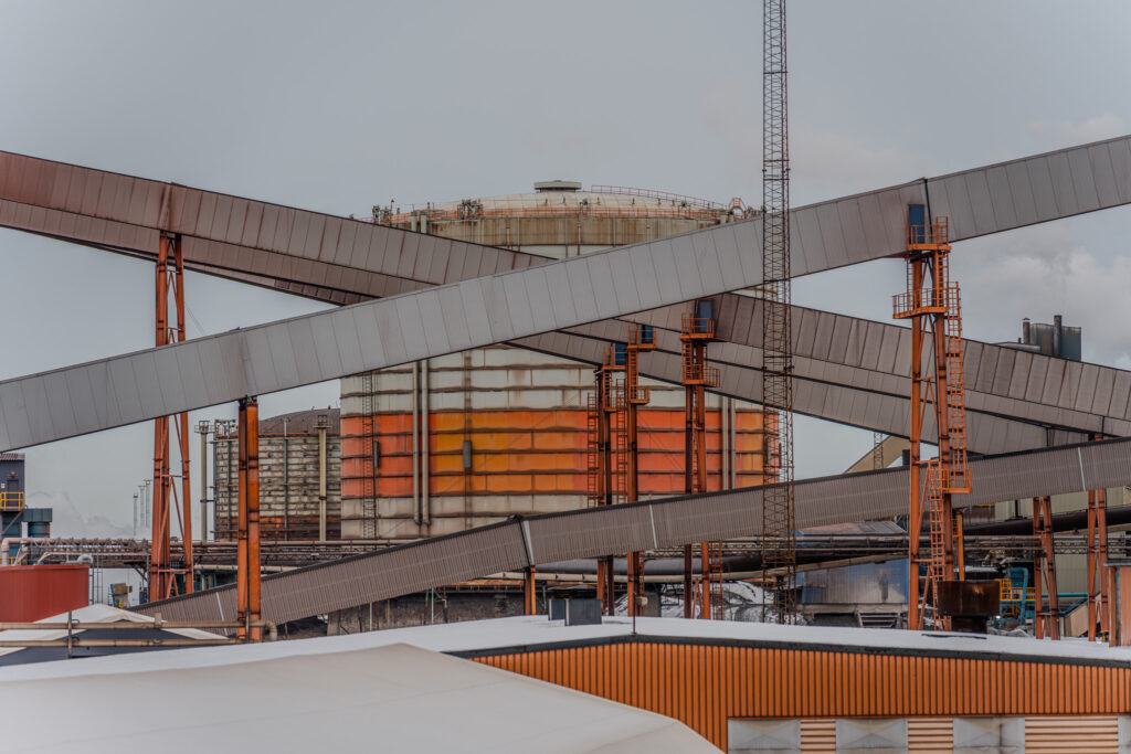 A photograph of the gasometer at the Luleå SSAB ironworks. Conveyor systems are crossing the view.